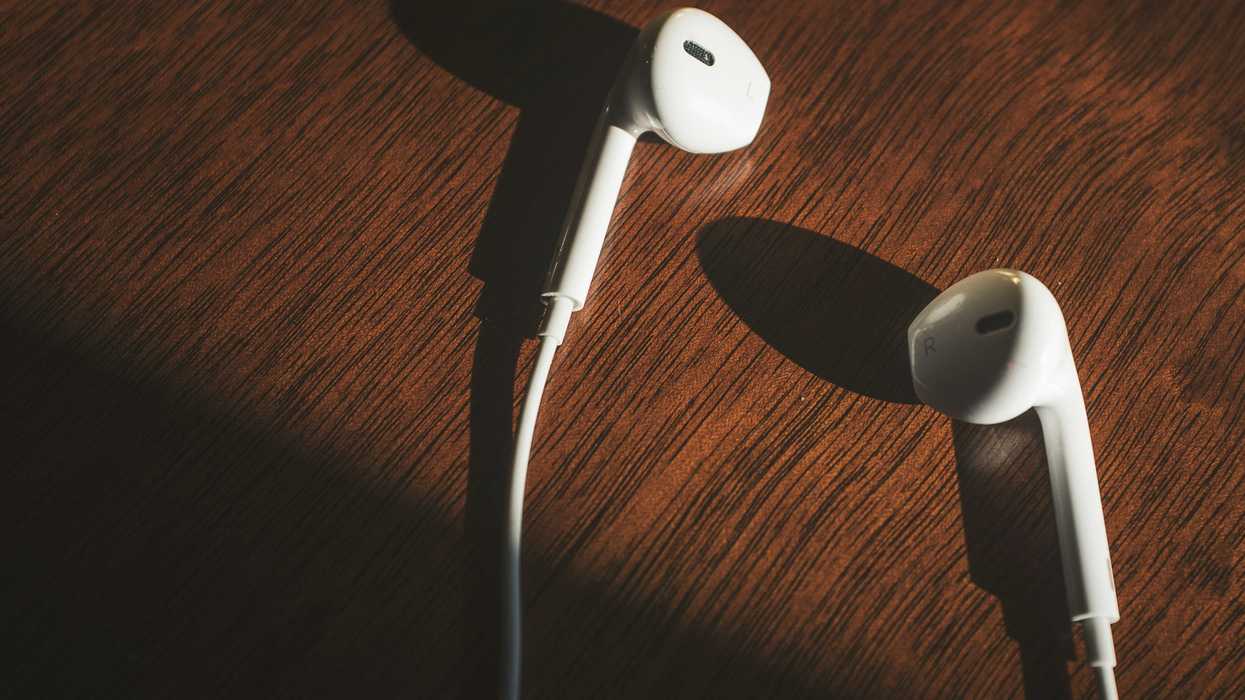 white earbuds on brown wooden table.