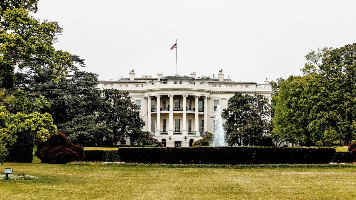 White House with lawn and trees in forground.
