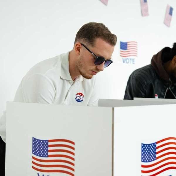 White man and black man in adjacent voting booths, voting in US election