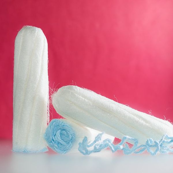 White tampons in front of a pink background.