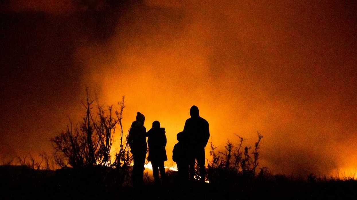 Wildfire observers silhuouetted against glowing horizon