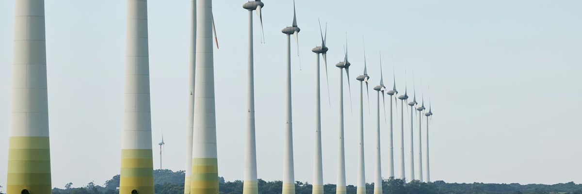 wind turbines lined up in a green field