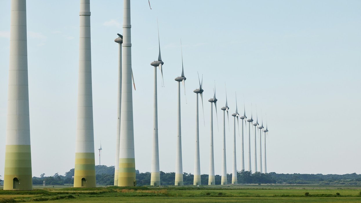 wind turbines lined up in a green field