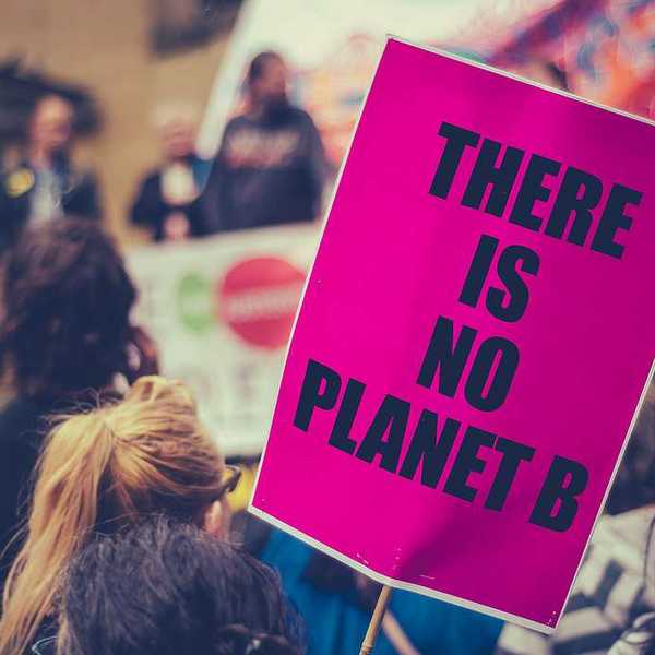 Woman carrying a sign saying There is no planet B