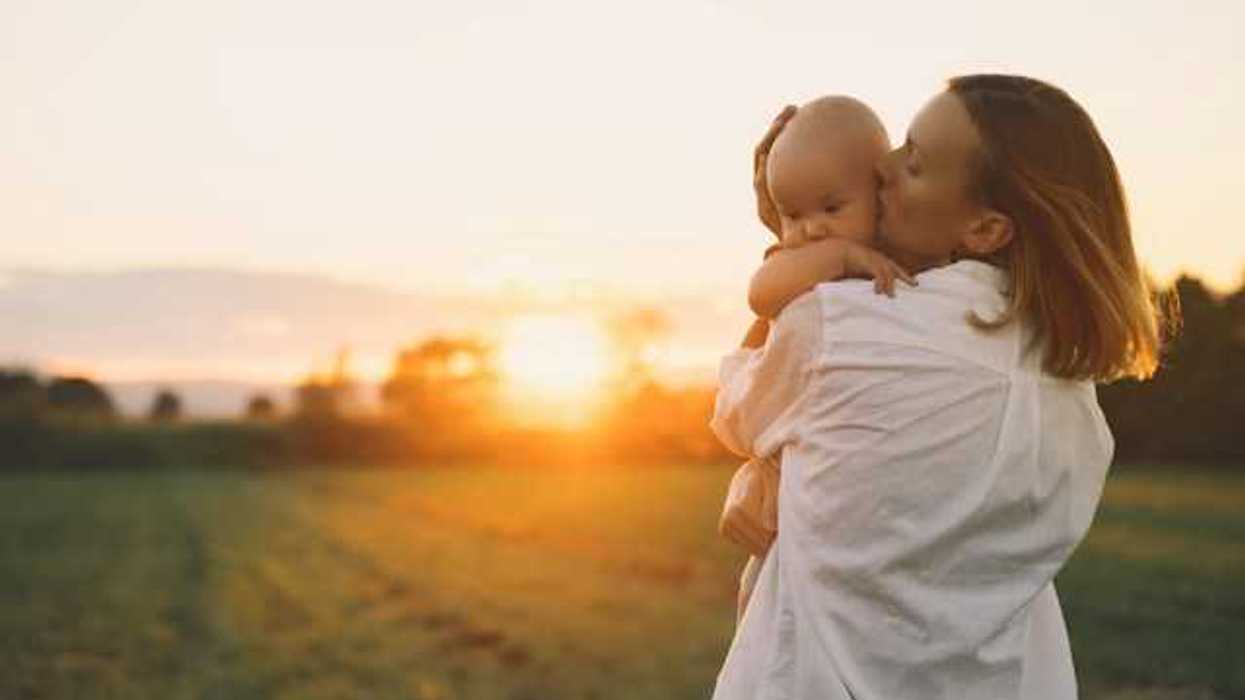 Woman holding a baby in a golden field