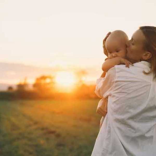 Woman holding a baby in a golden field