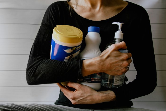 woman holding cleaning products toxic