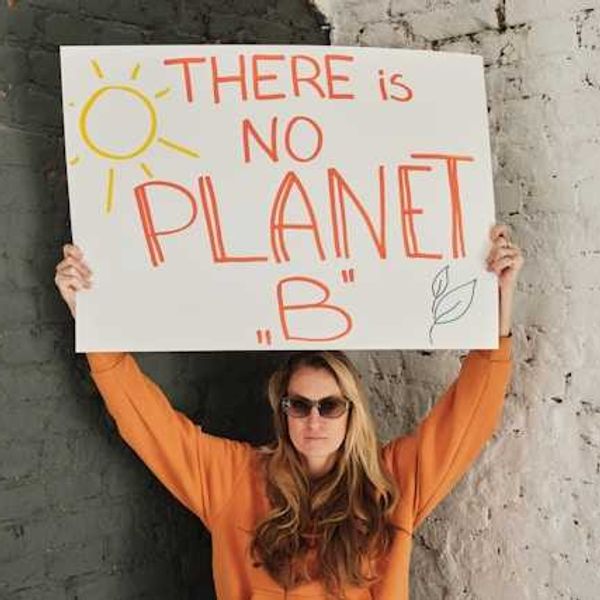 Woman holding sign that says There is no Planet B