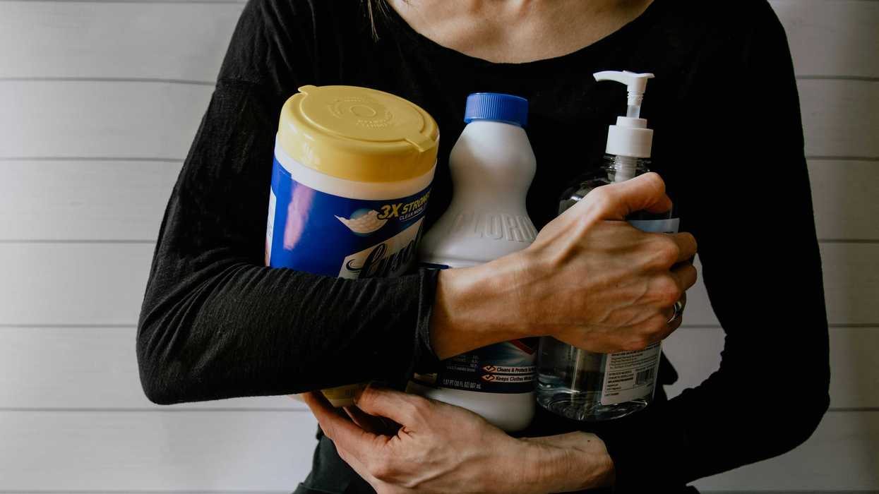 woman in black long sleeve shirt holding white and yellow plastic bottle.