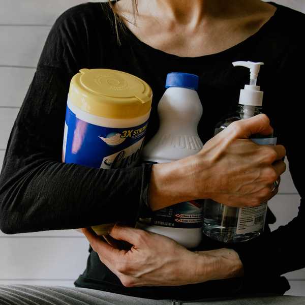 woman in black long sleeve shirt holding white and yellow plastic bottle.