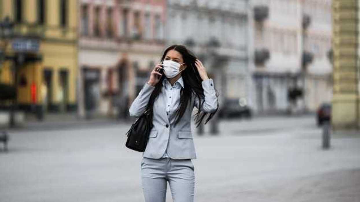 Woman in business suit with a protective mask over her face