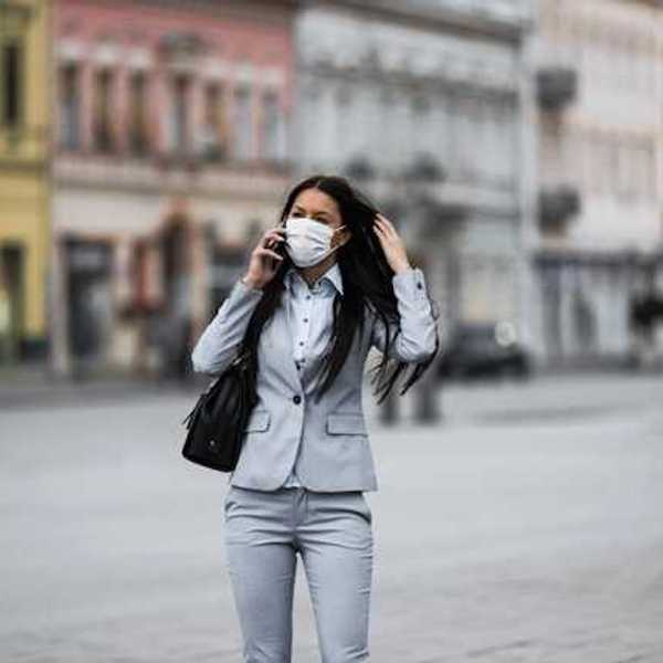 Woman in business suit with a protective mask over her face