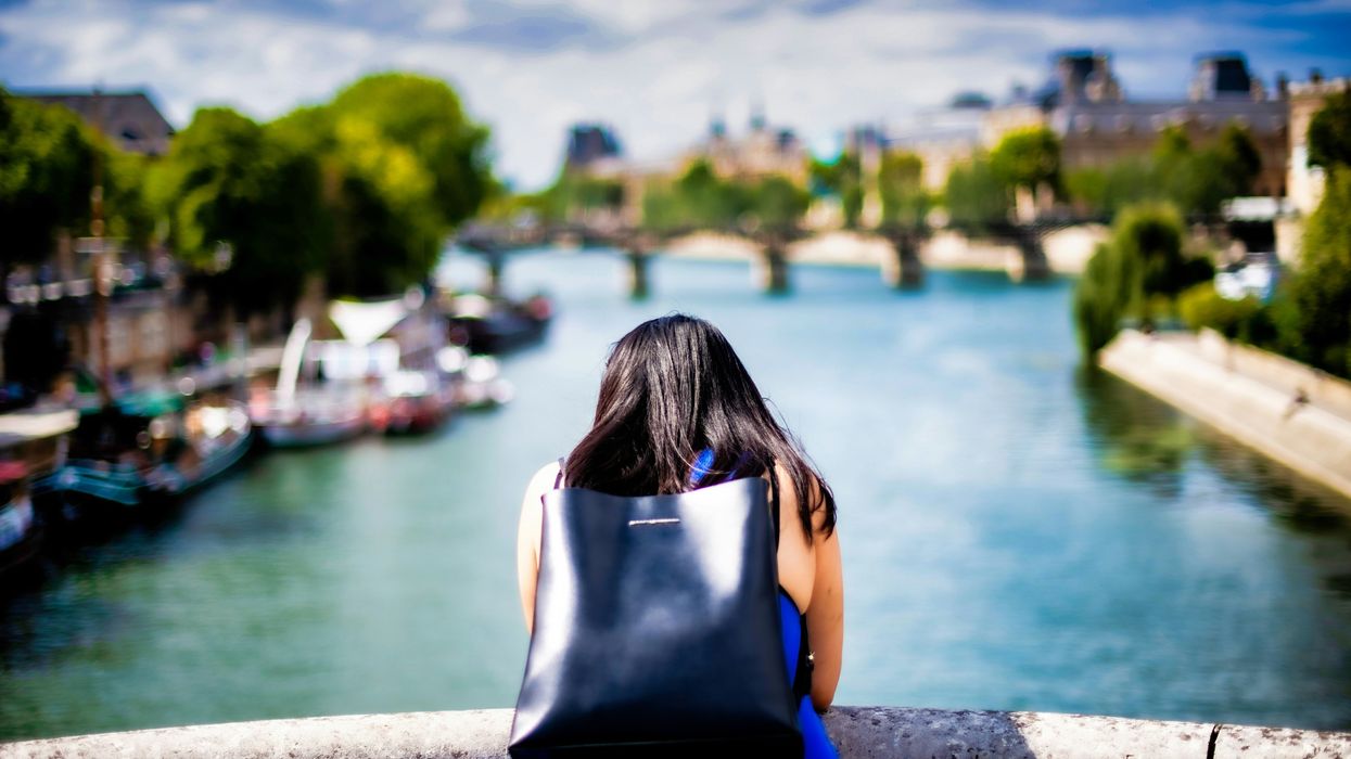woman on bridge looking at river