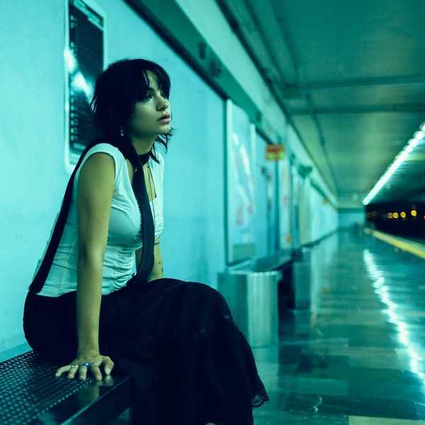 Woman seated on bench in underground station, waiting for subway for train