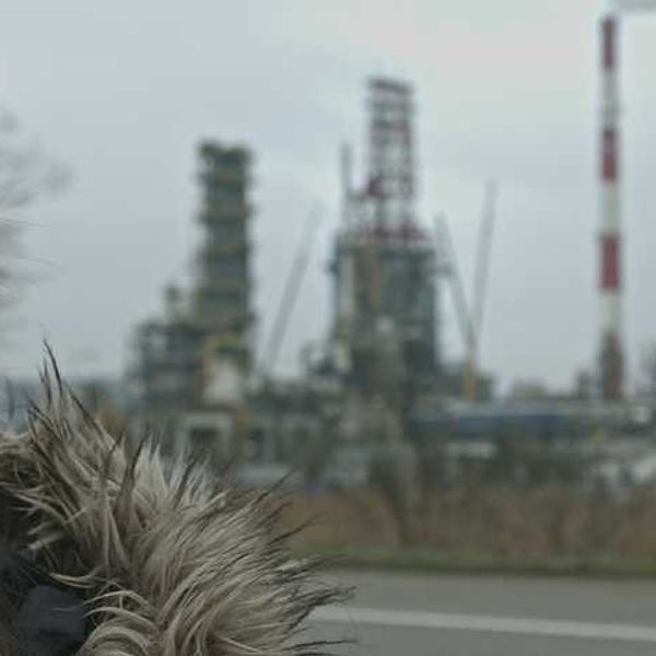 Woman wearing face mask standing in front of an industrial building