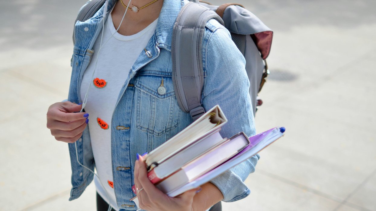 woman with backpack on carrying books