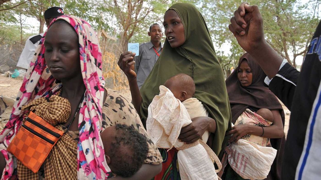 Women and children wait in line for food at refugee camp