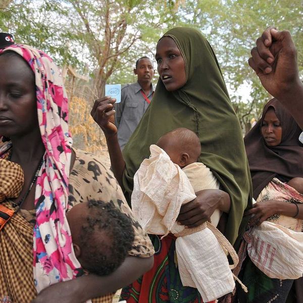 Women and children wait in line for food at refugee camp