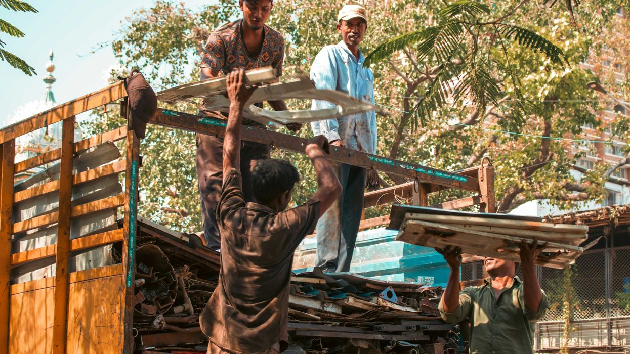 Workers loading scrap metal onto a truck.