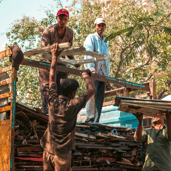 Workers loading scrap metal onto a truck.