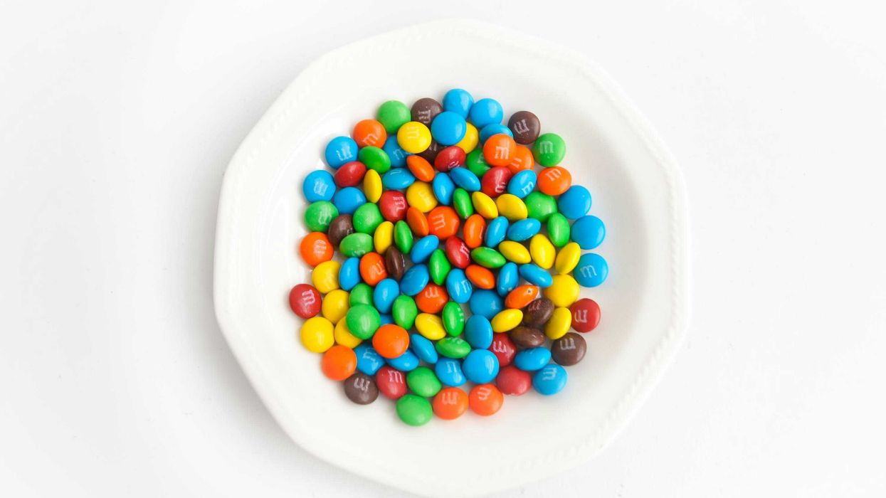 yellow green  blue and red candies on white ceramic round plate.
