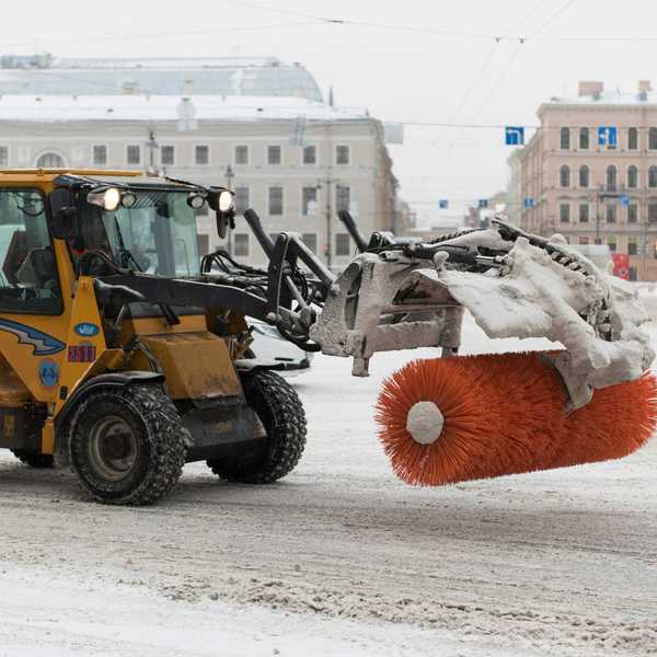 Yellow snow clearer with red roller brush on a street during daytime