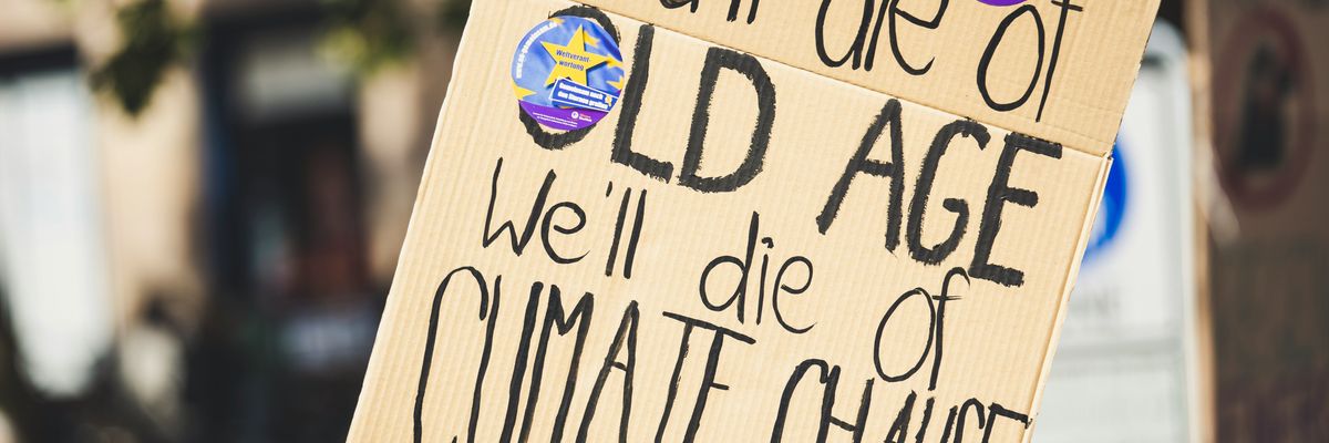 you'll die of old age we'll die of climate change text on protest sign.