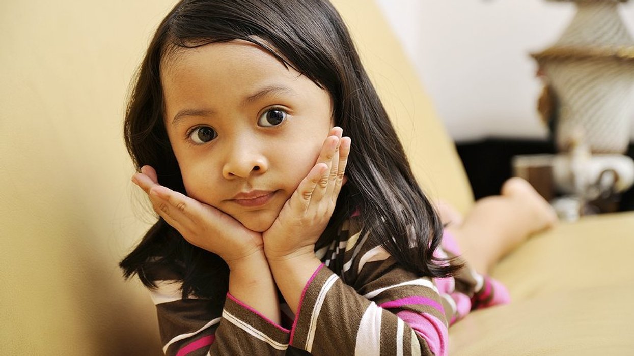 Young Indonesian girl lying on the couch looking into the camera